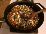 a skillet contained cooked whole grain couscous, chopped vegetables, raisins and feta cheese