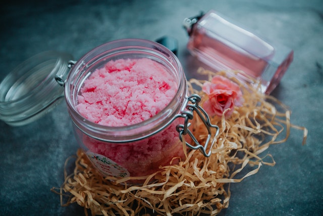 Pink bath salts in a glass mason jar.