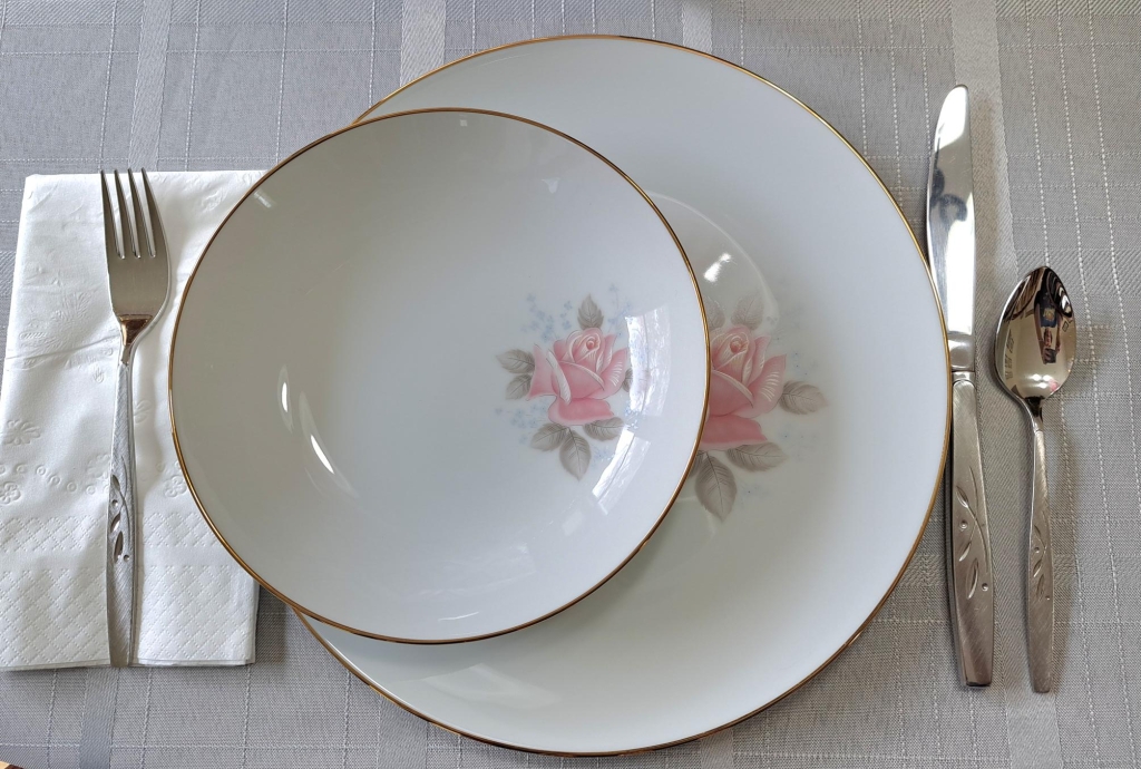 Image of a single place setting of fancy china and flatware.